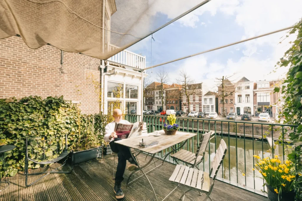 Man op terras aan het water kamer / suite 4 hotel Goud en Zilver